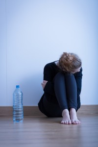 Ashamed woman, sitting on the floor